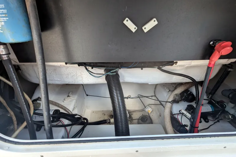 Slide: The Image of Engine compartment of a 2016 Sailfish 240 CC boat, showing hoses and wiring. - 14