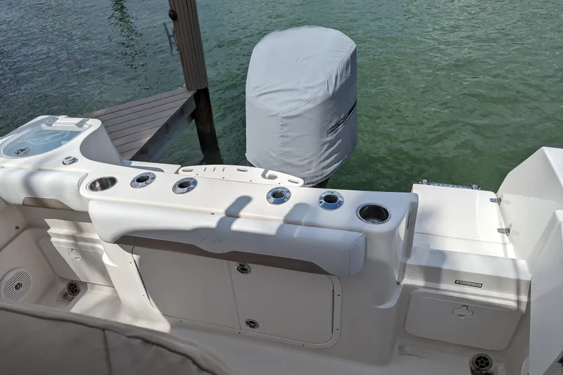 Slide: The Image of 2016 Sailfish 240 CC boat stern with covered outboard motor and rod holders. - 15