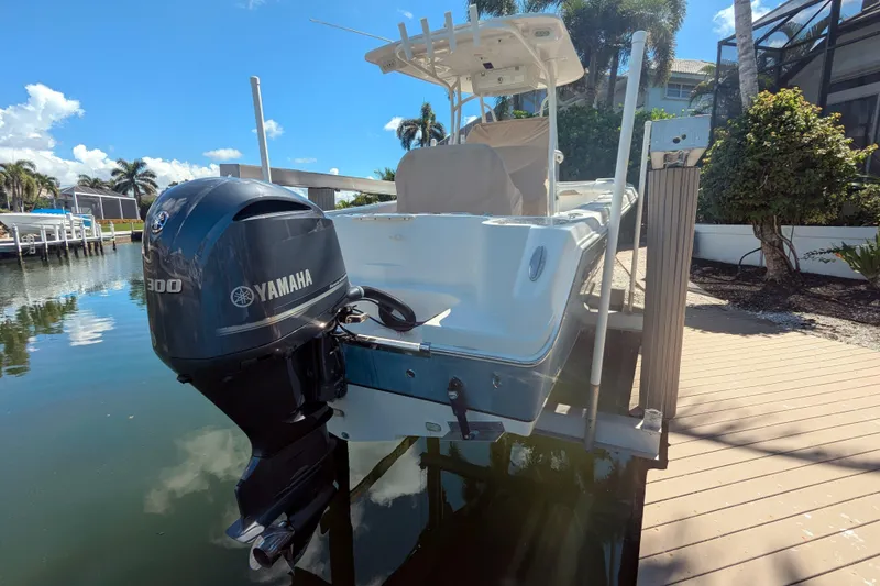 Slide: The Image of 2016 Sailfish 240 CC boat with Yamaha 300 engine docked by a waterfront. - 2