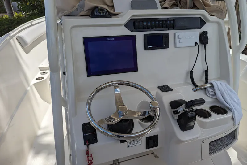 Slide: The Image of 2016 Sailfish 240 CC boat dashboard with steering wheel, navigation screen, and controls. - 5