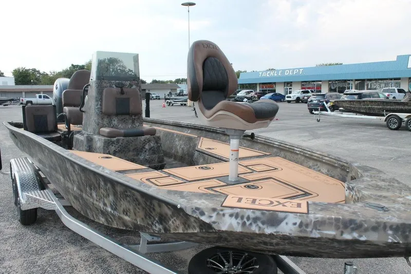 Slide: The Image of 2026 Excel Bay Pro Elite 203 boat displayed at dealership, featuring camo design and elevated seating. - 8