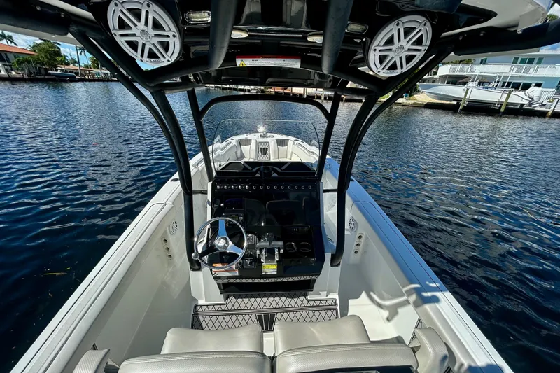Slide: The Image of 2022 Wellcraft 242 Fisherman boat interior with steering wheel, docked on calm water. - 13