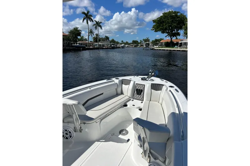 Slide: The Image of 2022 Wellcraft 242 Fisherman boat on a scenic waterway with palm trees and blue sky. - 14