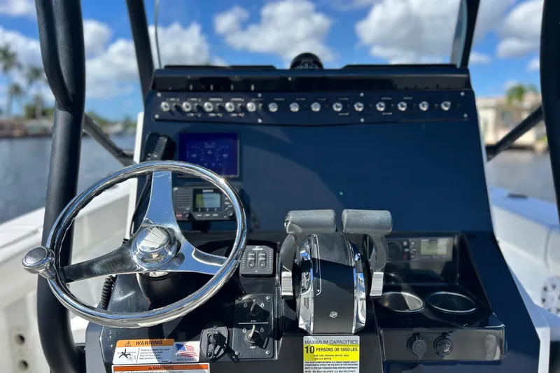 Slide: The Image of 2022 Wellcraft 242 Fisherman boat dashboard with steering wheel and controls. - 5