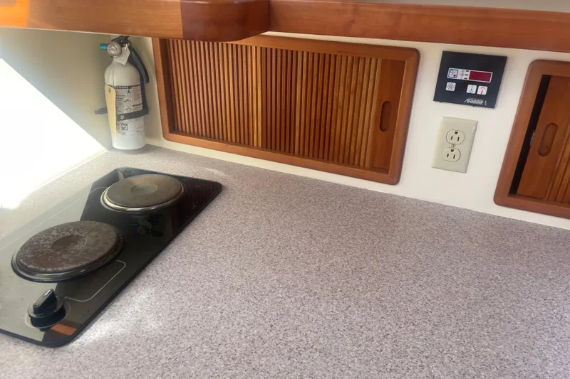 Slide: The Image of 1998 Little Harbor WhisperJet 36 galley with stove, fire extinguisher, and wooden cabinets. - 13