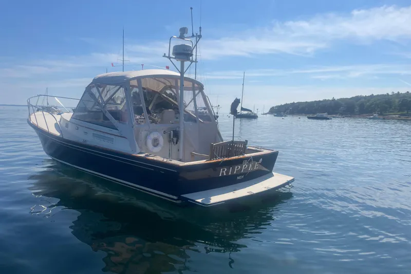 Slide: The Image of 1998 Little Harbor WhisperJet 36 boat anchored in calm waters, clear blue sky. - 2
