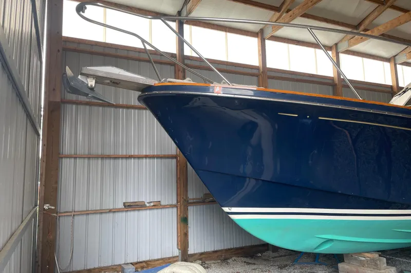 Slide: The Image of 1998 Little Harbor WhisperJet 36 boat in storage, blue hull, green bottom, metal shed. - 20