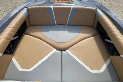Slide: The Image of 2021 Tigé 23RZX boat interior with tan and gray seating. - 10