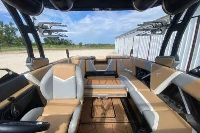 Slide: The Image of 2021 Tigé 23RZX boat interior with tan and white seating, open sky view. - 11