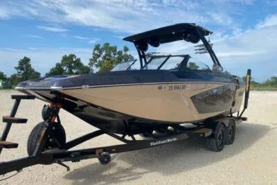 Slide: The Image of 2021 Tigé 23RZX boat on trailer, parked outdoors under a clear sky. - 3