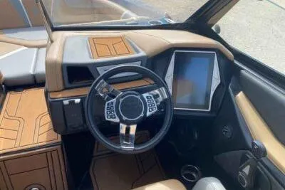 Slide: The Image of 2021 Tigé 23RZX boat interior with modern steering wheel and touchscreen display. - 8