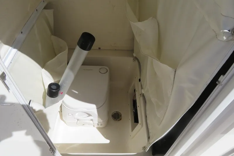 Slide: The Image of 2021 Key West 239 FS boat interior with compact marine toilet setup. - 27