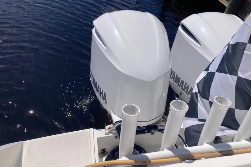 Slide: The Image of Twin Yamaha outboard motors on a 2016 Tarpon 326 boat, docked by the water. - 10