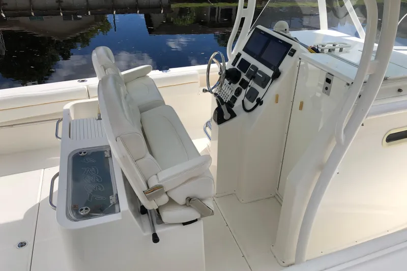 Slide: The Image of 2016 Tarpon 326 boat interior with helm, seating, and control panel by the water. - 15