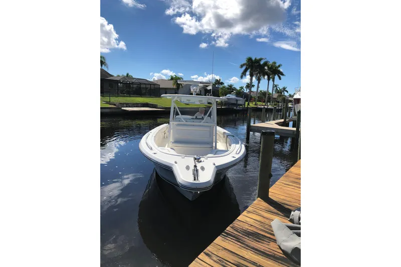 Slide: The Image of 2016 Tarpon 326 boat docked on a sunny day with palm trees in the background. - 3