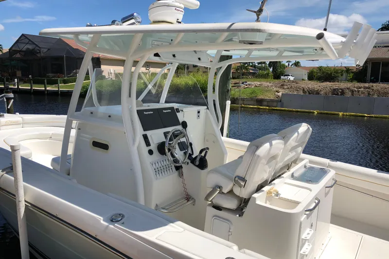 Slide: The Image of 2016 Tarpon 326 boat with dual seats and navigation equipment, docked by a canal. - 7