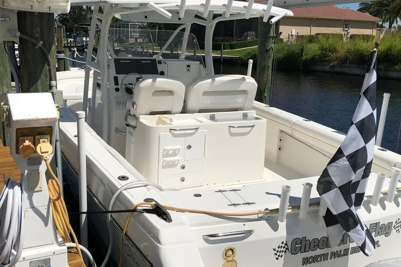 Slide: The Image of 2016 Tarpon 326 boat docked, featuring a checkered flag and dual seating. - 9