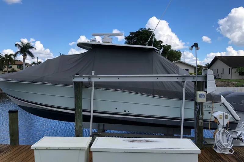 Slide: The Image of 2016 Stamas TARPON 326 boat covered at dock, under a clear blue sky. - 22