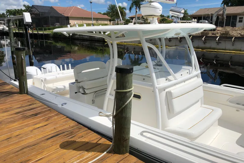 Slide: The Image of 2016 Tarpon 326 boat docked, featuring a sleek white design and spacious seating. - 6