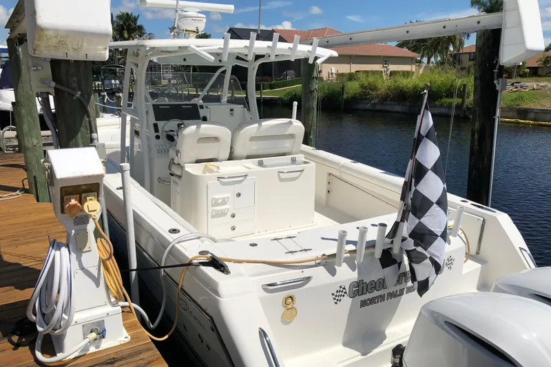 Slide: The Image of 2016 Tarpon 326 boat docked, featuring a checkered flag and modern amenities. - 8
