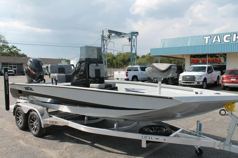 Slide: The Image of 2026 Excel Bay Pro Elite 203 boat on trailer outside tackle shop. - 4