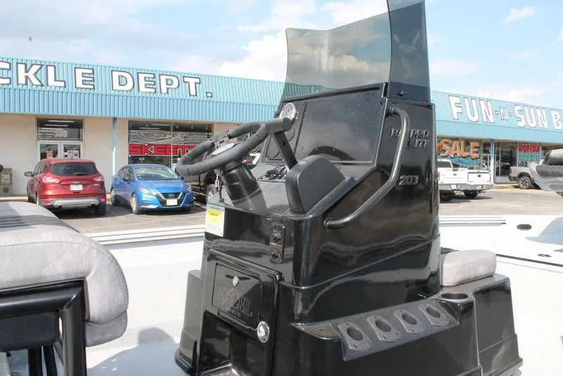 Slide: The Image of 2026 Excel Bay Pro Elite 203 boat console at dealership, with storefront in background. - 6