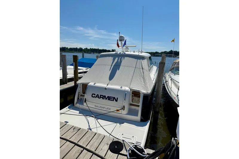 Slide: The Image of 2006 Tiara Yachts 4400 Sovran docked, covered, with clear sky and water view. - 2