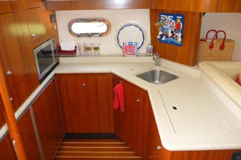 Slide: The Image of Luxurious 2006 Tiara 44' Sovran yacht kitchen with wood cabinetry and modern amenities. - 21