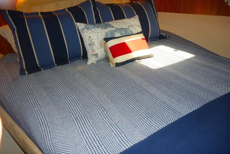 Slide: The Image of Luxurious bedroom interior of 2006 Tiara 44' Sovran yacht with nautical-themed bedding. - 23