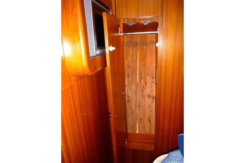 Slide: The Image of Interior of 2006 Tiara 44' Sovran yacht with wooden cabinetry and open closet. - 25