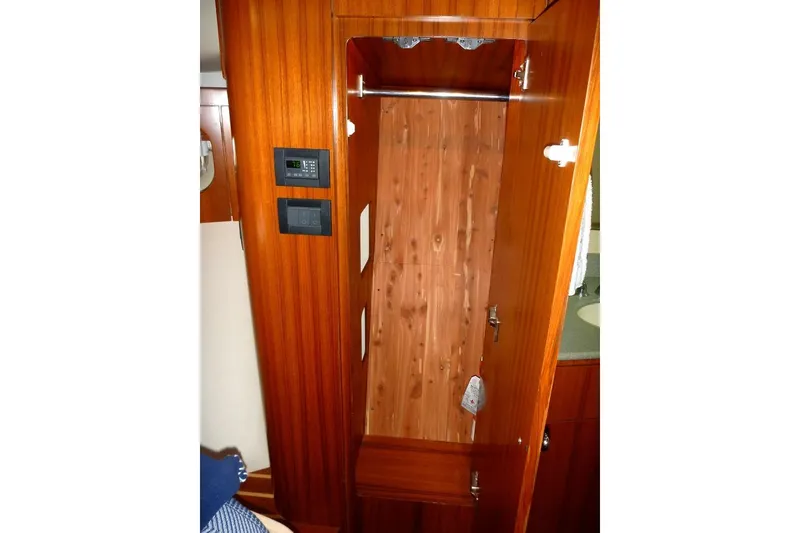 Slide: The Image of Wooden closet interior on 2006 Tiara 44' Sovran yacht, featuring control panels. - 26