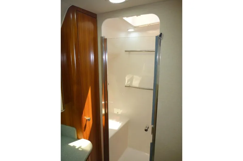 Slide: The Image of 2006 Tiara 44' Sovran yacht bathroom with wooden cabinetry and glass shower door. - 29