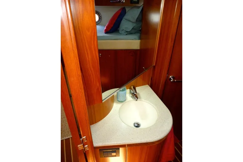 Slide: The Image of 2006 Tiara 44' Sovran yacht interior with wooden cabinetry and compact bathroom sink. - 33