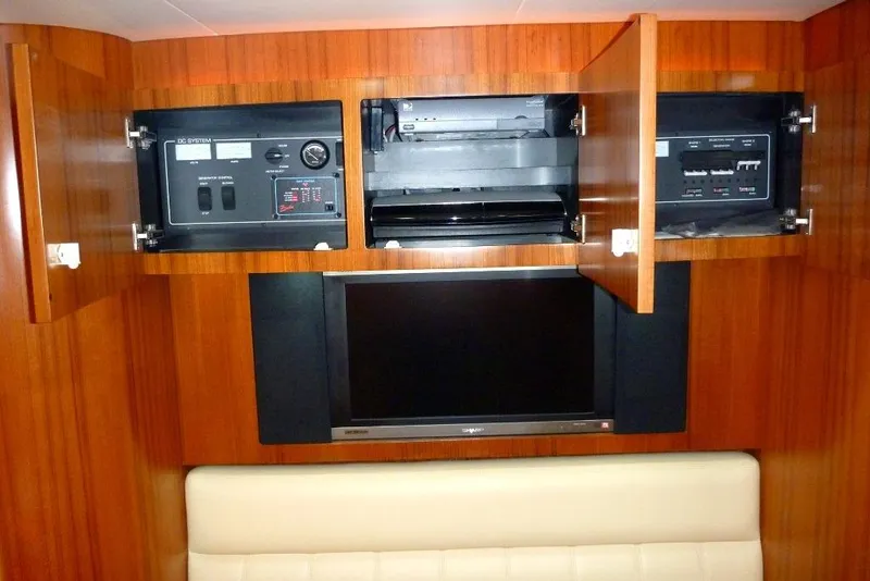 Slide: The Image of 2006 Tiara 44' Sovran yacht interior with open cabinets and a flat-screen TV. - 36