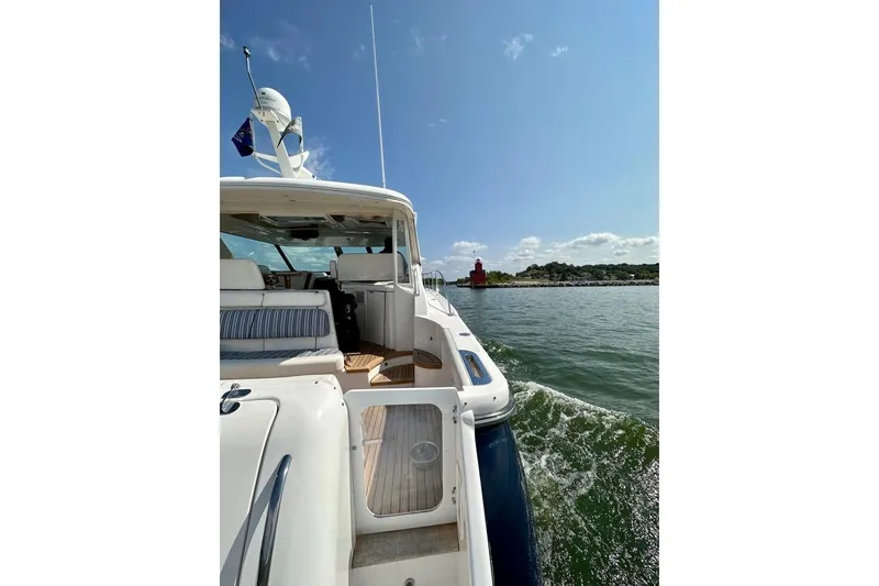 Slide: The Image of 2006 Tiara Yachts 4400 Sovran cruising near a lighthouse on a sunny day. - 47