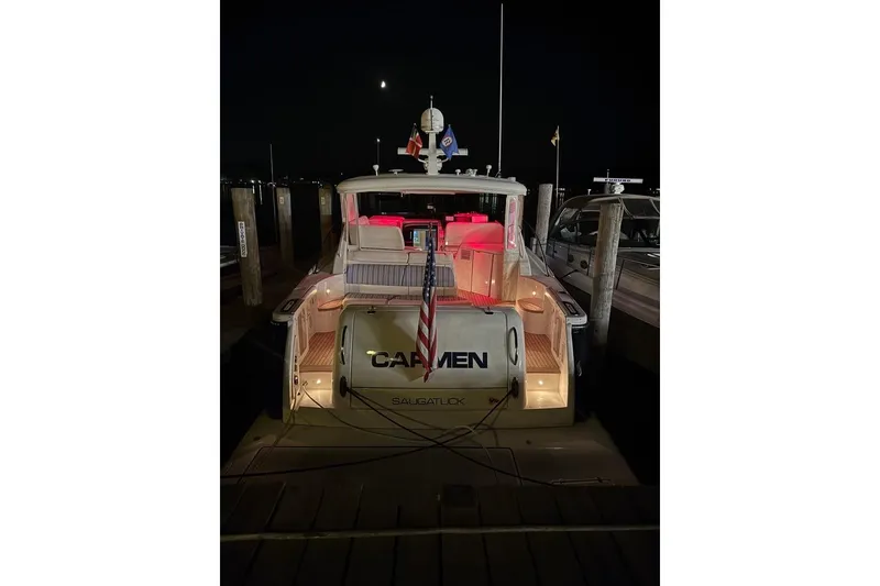 Slide: The Image of 2006 Tiara Yachts 4400 Sovran docked at night with illuminated interior. - 48