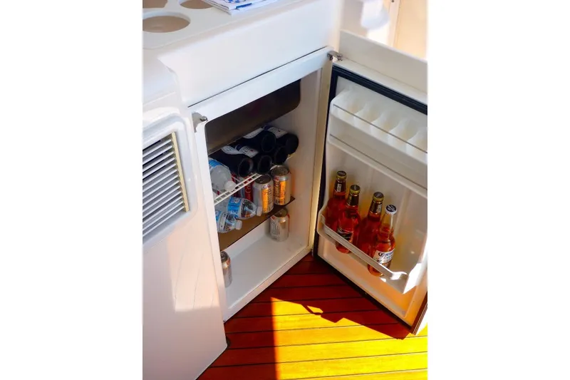 Slide: The Image of Mini fridge stocked with drinks on 2006 Tiara 44' Sovran yacht, wooden floor visible. - 9
