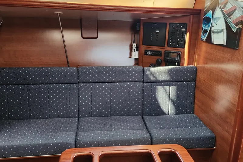 Slide: The Image of Interior of 2012 Hunter e 33 sailboat with blue cushioned seating and control panel. - 13