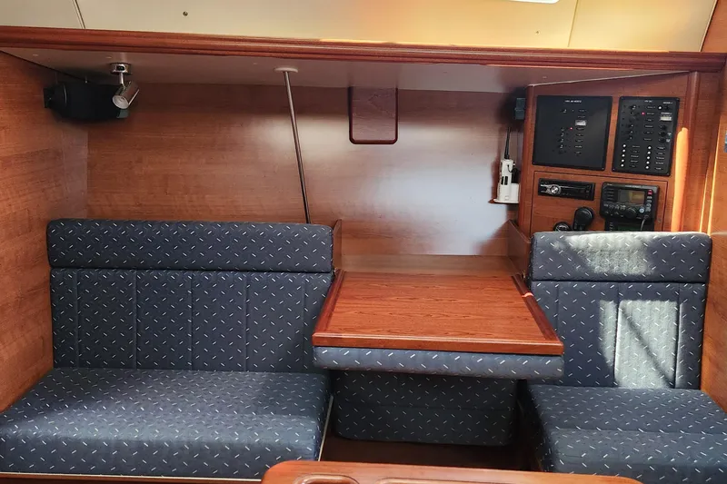 Slide: The Image of 2012 Hunter e 33 yacht interior with wood paneling and blue cushioned seating. - 14