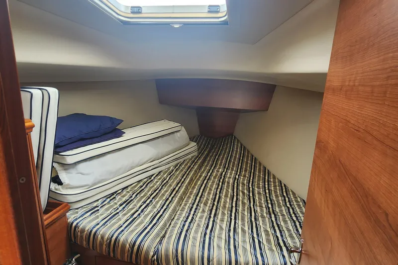 Slide: The Image of Cozy cabin interior of 2012 Hunter e 33 sailboat with striped bedding and skylight. - 16