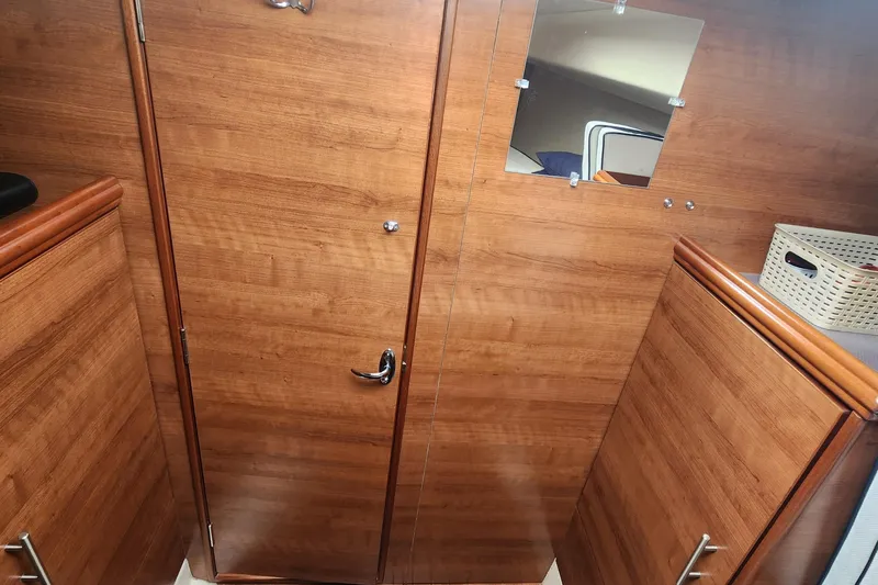 Slide: The Image of Interior of 2012 Hunter e 33 sailboat with wooden cabinetry and mirror. - 19