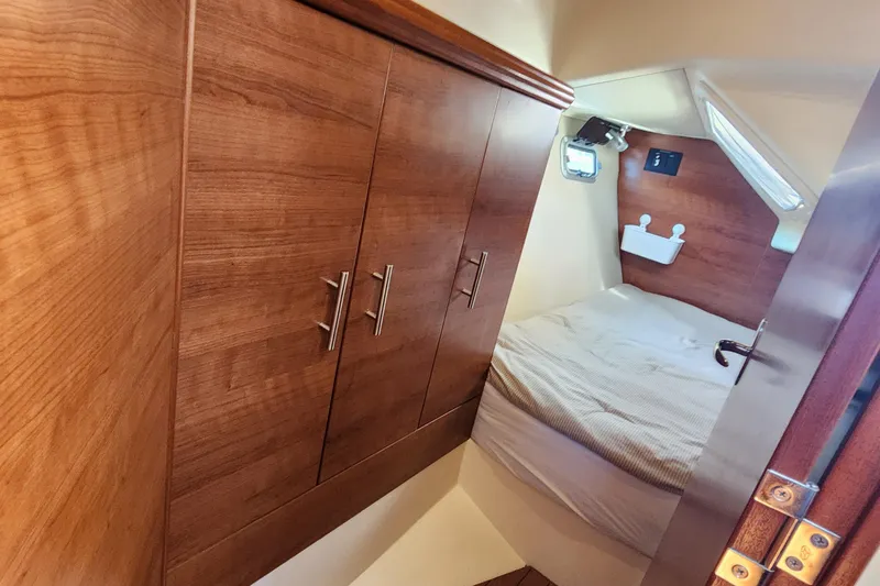 Slide: The Image of Cozy cabin interior of 2012 Hunter e 33 sailboat with wooden cabinetry and bed. - 22
