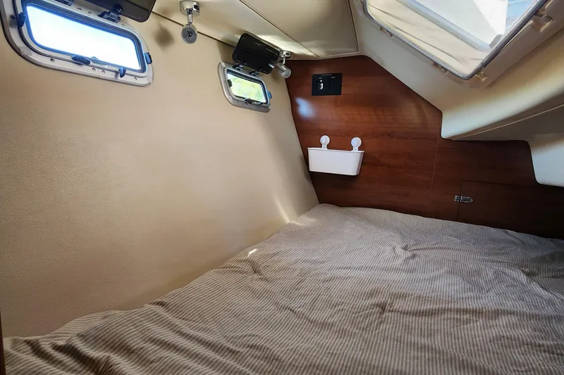 Slide: The Image of 2012 Hunter e 33 yacht cabin interior with cozy bed and porthole windows. - 23