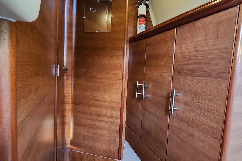 Slide: The Image of Interior of 2012 Hunter e 33 sailboat with wooden cabinets and fire extinguisher. - 24