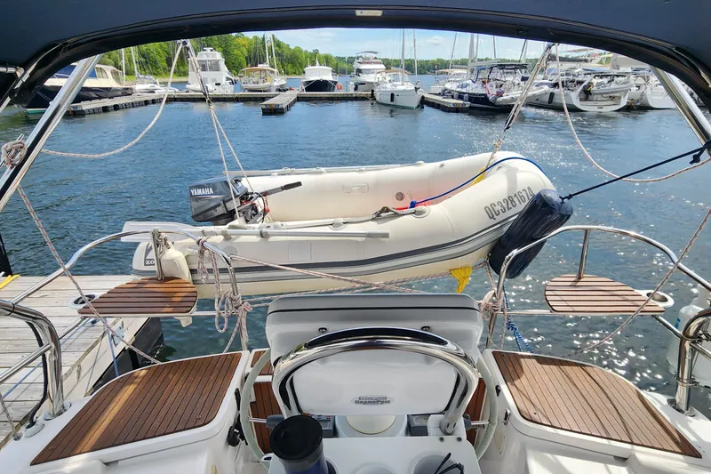 Slide: The Image of 2012 Hunter e 33 sailboat with dinghy, docked at marina, surrounded by other boats. - 5