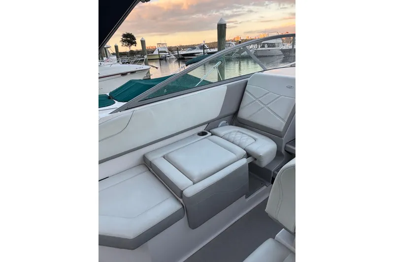 Slide: The Image of 2021 Regal 26 Express boat interior with white seating at marina during sunset. - 5