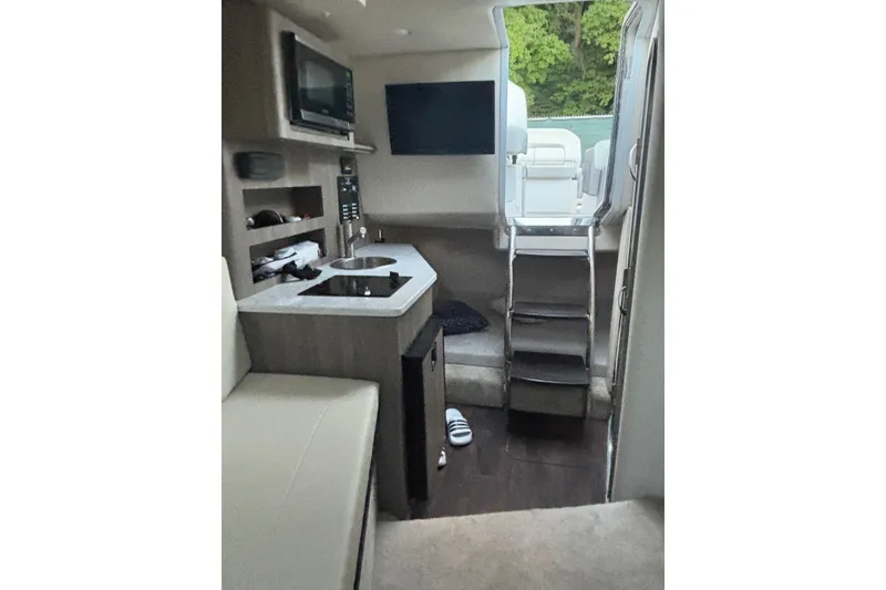 Slide: The Image of Interior of 2021 Regal 26 Express boat with kitchenette and seating area. - 7