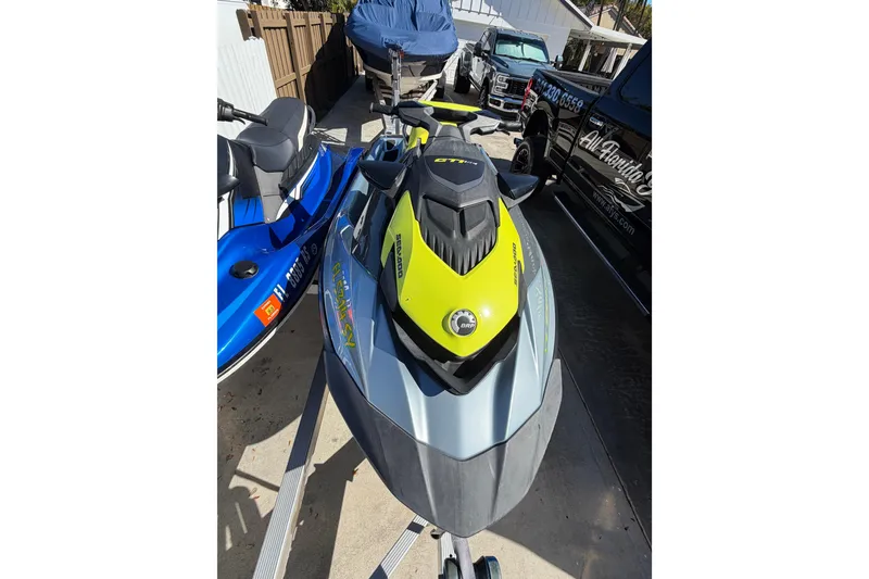 Slide: The Image of 2021 Sea-Doo GTI SE 130 jet ski in driveway, vibrant yellow and gray design. - 19