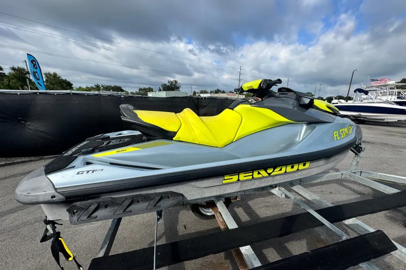 Slide: The Image of 2021 Sea-Doo GTI SE 130 jet ski with yellow and gray design on a trailer. - 2