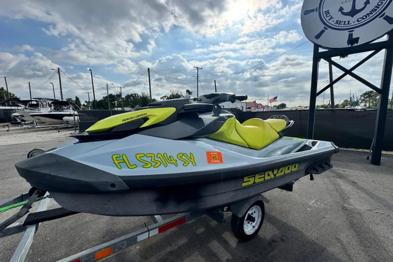 Slide: The Image of 2021 Sea-Doo GTI SE 130 jet ski on trailer, parked outdoors under cloudy sky. - 5